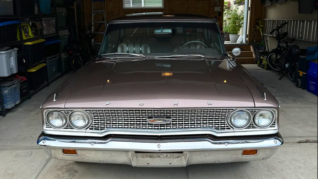 Front of a 1963 Ford Galaxie in a garage, chrome grille and bumper polished